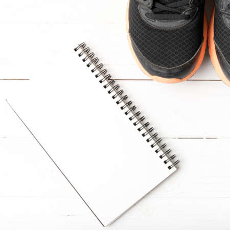running shoes and notepad on white wood tableの写真素材
