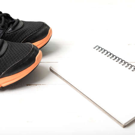running shoes and notepad on white wood tableの写真素材