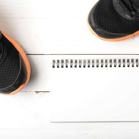 running shoes and notepad on white wood tableの写真素材