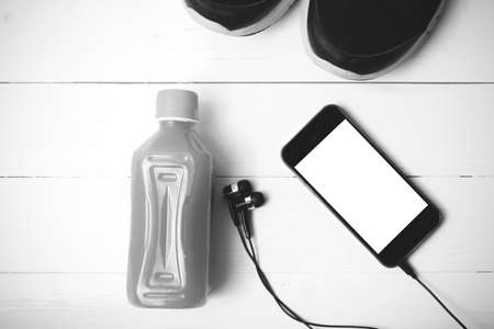running shoes,orange juice and phone on white wood background black and white tone color styleの写真素材