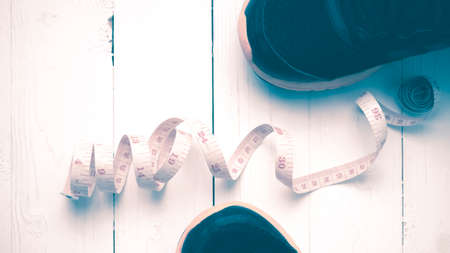 running shoes and measuring tape on white wood table vintage styleの写真素材