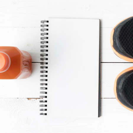 running shoes,orange juice and notepad on white wood backgroundの写真素材