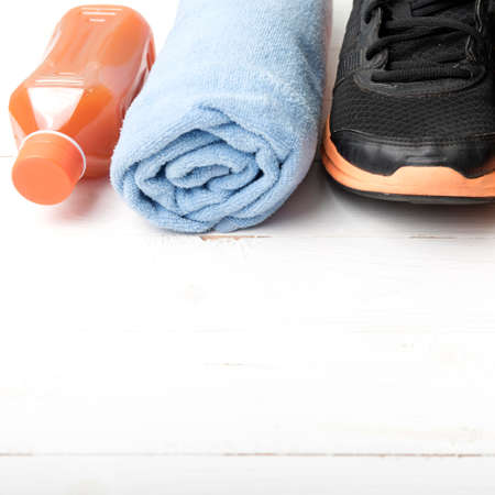 running shoes,towel and orange juice on white wood tableの写真素材