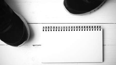 running shoes and notepad on white wood table black and white tone color styleの写真素材