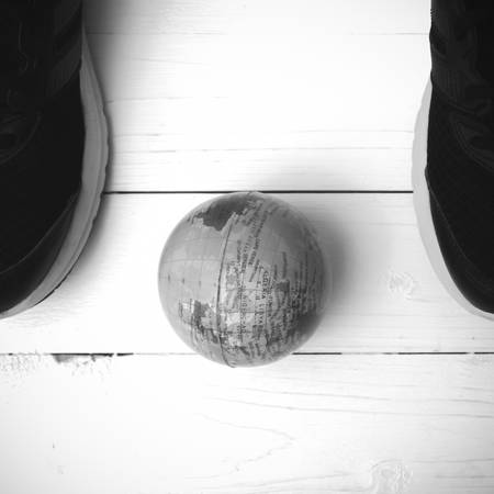 running shoes and earth ball on white wood table concept world healthy black and white tone color styleの写真素材