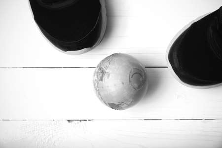 running shoes and earth ball on white wood table concept world healthy black and white tone color styleの写真素材