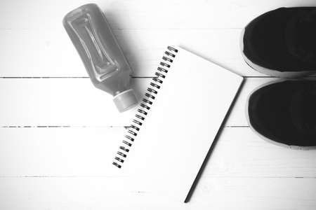 running shoes,orange juice and notepad on white wood background black and white tone color styleの写真素材