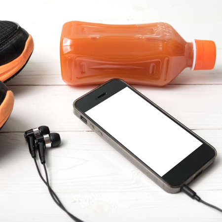 running shoes,orange juice and phone on white wood backgroundの写真素材