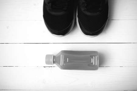 running shoes and orange juice on white wood table black and white tone color styleの写真素材