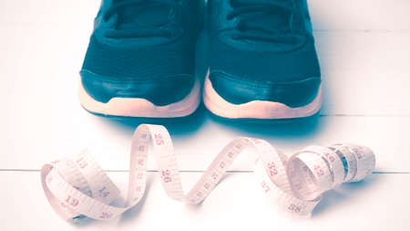 running shoes and measuring tape on white wood table vintage styleの写真素材
