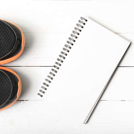 running shoes and notepad on white wood tableの写真素材