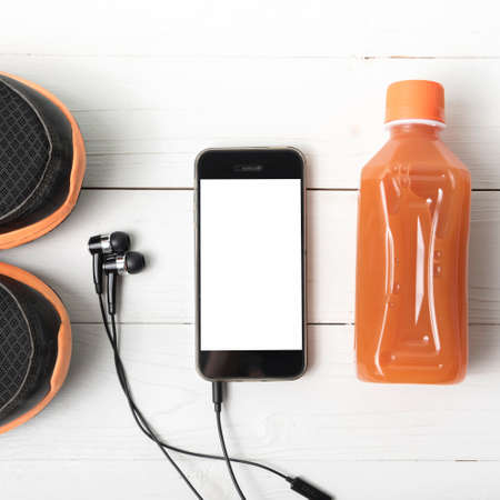 running shoes,orange juice and phone on white wood backgroundの写真素材