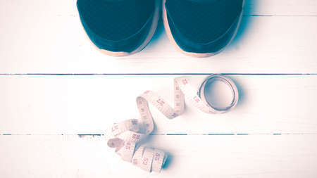 running shoes and measuring tape on white wood table vintage style