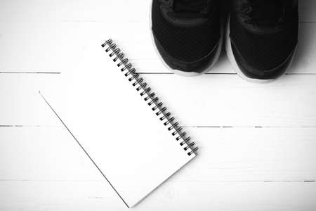 running shoes and notepad on white wood table black and white tone color styleの写真素材