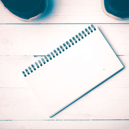 running shoes and notepad on white wood table vintage styleの写真素材