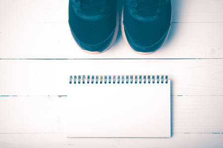 running shoes and notepad on white wood table vintage styleの写真素材