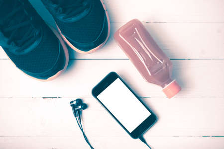 running shoes,orange juice and phone on white wood background vintage tone color styleの写真素材