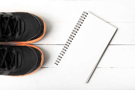 running shoes and notepad on white wood tableの写真素材