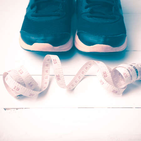 running shoes and measuring tape on white wood table vintage styleの写真素材