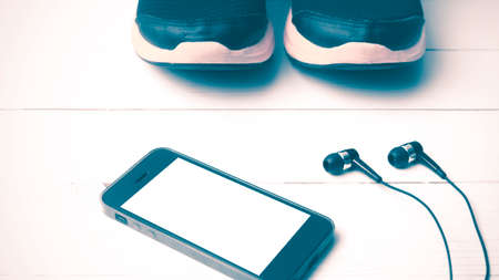 running shoes and phone on white wood table vintage style