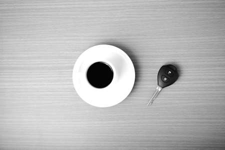 coffee cup and car key on wood background  black and white colorの写真素材