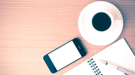 coffee cup and phone and notepad on wood background vintage styleの写真素材
