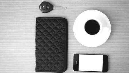 coffee cup with phone car key and wallet on wood background black and white colorの写真素材