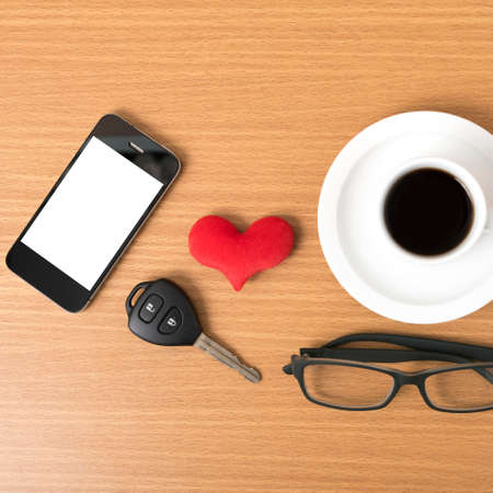 coffee,phone,eyeglasses and car key on wood table backgroundの写真素材
