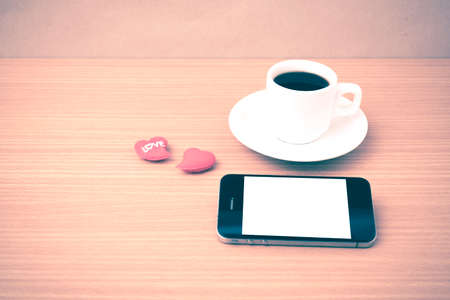coffee cup and phone and heart on wood background vintage style
