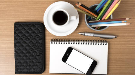 coffee,phone,eyeglasses,notepad,wallet and color pencil on wood table backgroundの写真素材