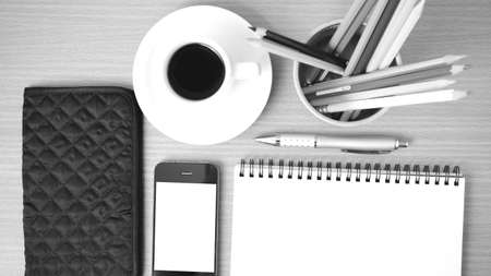 coffee,phone,eyeglasses,notepad,wallet and color pencil on wood table background  black  and white...