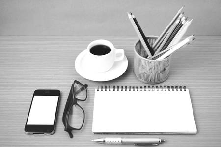 coffee,phone,eyeglasses,notepad and color pencil on wood table background black  and white color