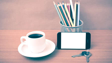coffee,phone,key and pencil on wood table background vintage style
