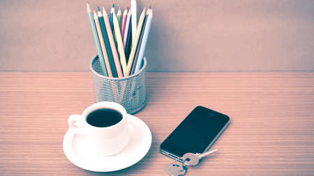 coffee,phone,key and pencil on wood table background vintage style