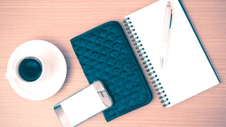coffee,phone,notepad and wallet on wood table background vintage style