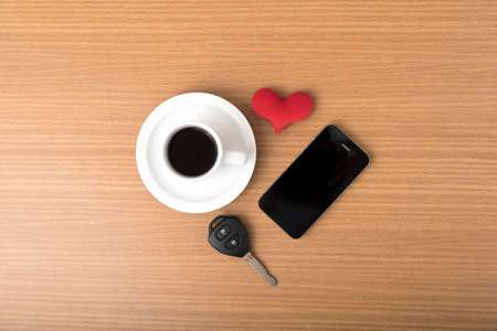 coffee phone car key and heart on wood table backgroundの写真素材