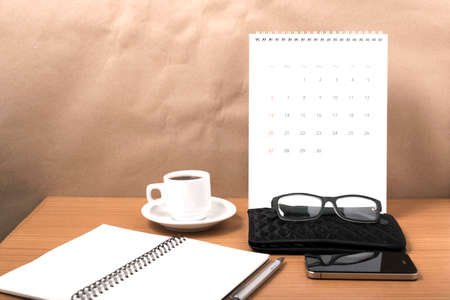 office desk : coffee with phone,calendar,wallet,notepad on wood backgroundの写真素材