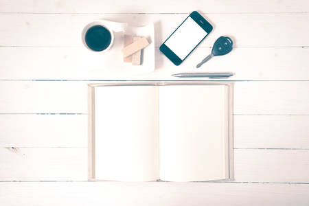coffee cup with wafer,phone,car key,notebook on white wood background vintage styleの写真素材