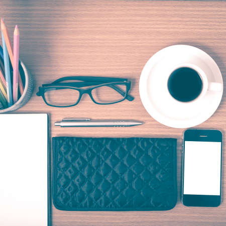 office desk : coffee with phone,notepad,eyeglasses,wallet,color pencil box on wood background...