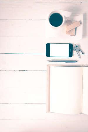 coffee cup with wafer,phone,key,notebook on white wood background vintage styleの写真素材