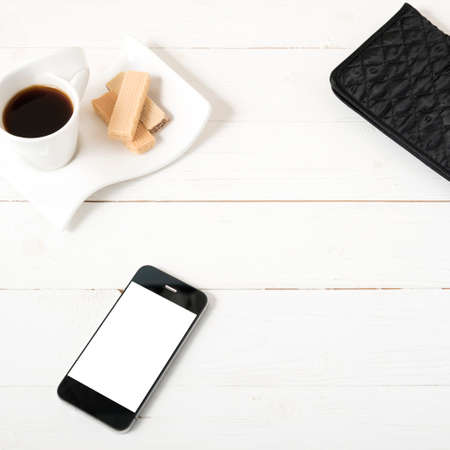 coffee cup with wafer,phone,wallet on white wood background