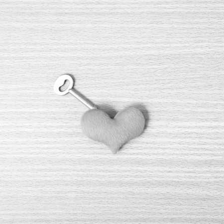 red heart with key on wood table background black and white color