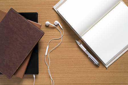 top view of stack of notebook with earphone on wood background concept audio bookの写真素材