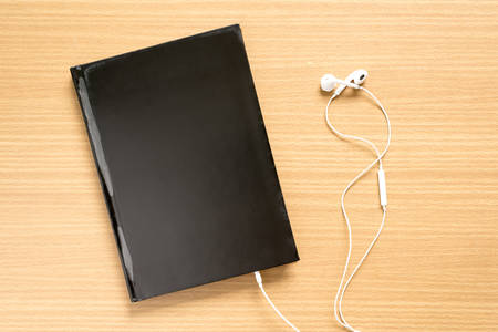 top view of notebook with earphone on wood backgroundの写真素材