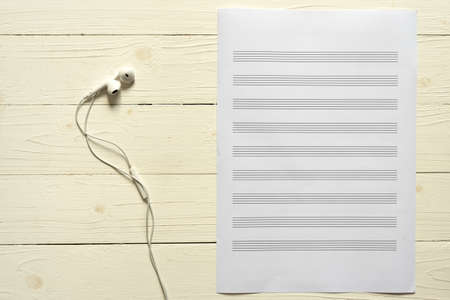 music staff paper with earphone on white wood backgroundの写真素材