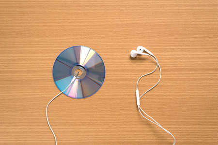 top view of dvd dish and earphone on wood backgroundの写真素材