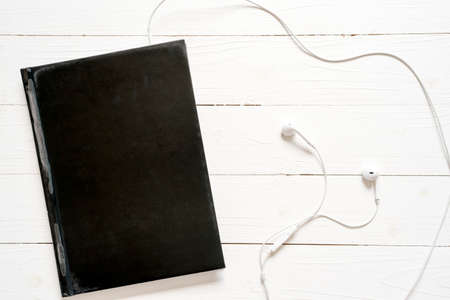 top view of notebook and earphone on wood backgroundの写真素材