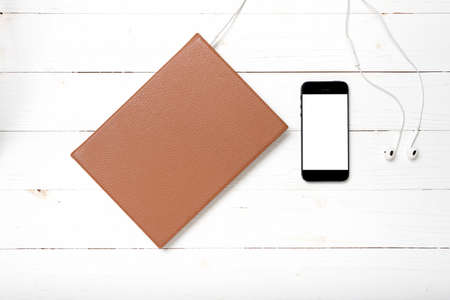 top view of earphone with notebook and phone