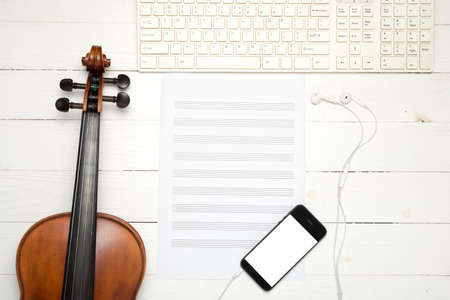 violin with  music paper note keyboard and smart phone on white wood backgroundの写真素材