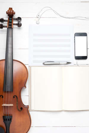 keyboard computer with notebook smart phone and violin on white backgroundの写真素材